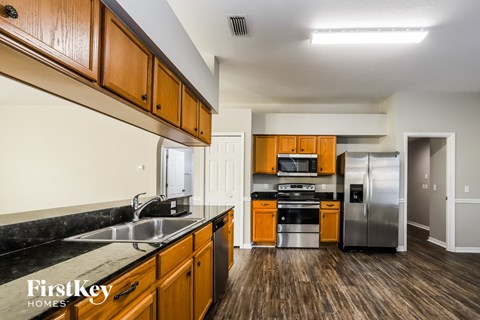 A kitchen with wooden cabinets and a black countertop.