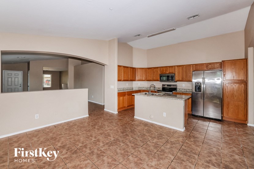 an empty kitchen with stainless steel appliances and wooden cabinets
