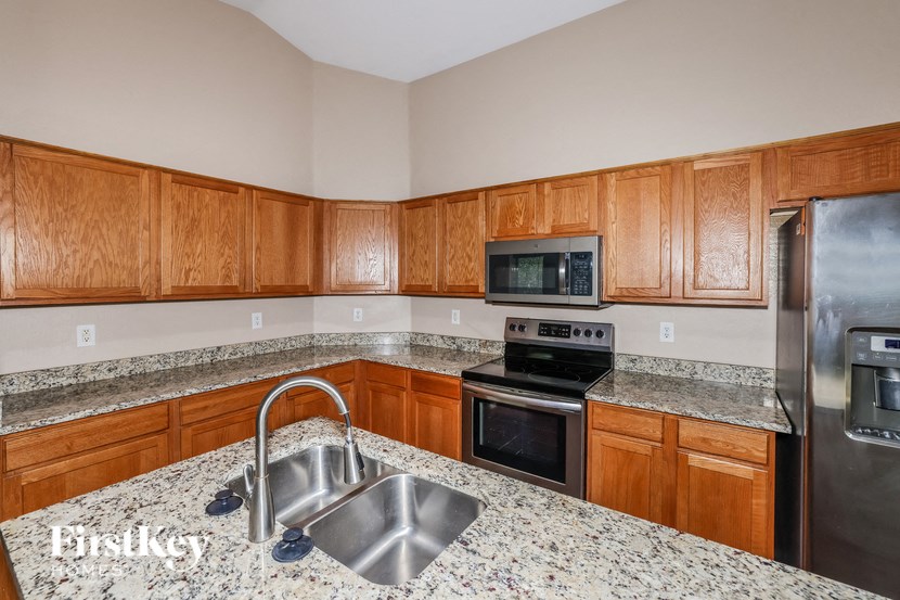 a kitchen with granite counter tops and wooden cabinets