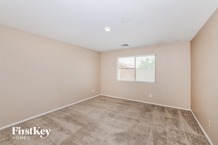 the spacious living room with carpeting and a window