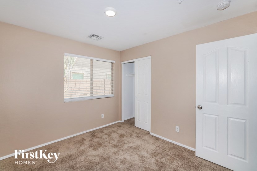 a bedroom with a closet and a window and a door