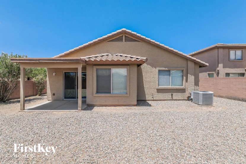 a small brick house with a driveway and a covered porch