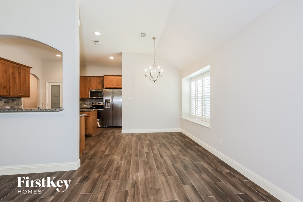 A kitchen with wooden floors and a chandelier.