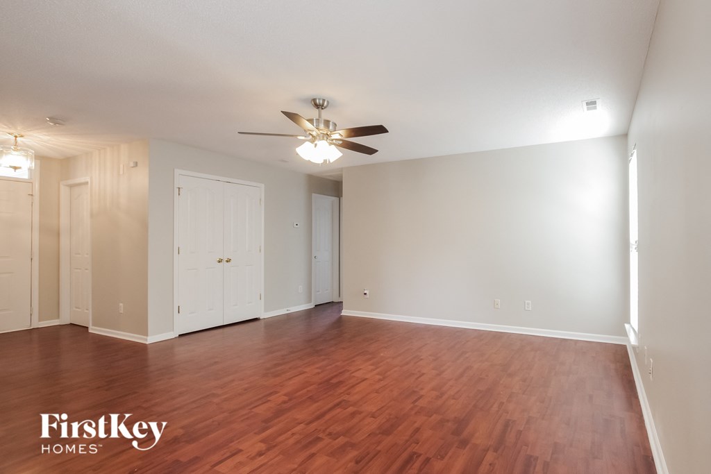 A room with wooden floors and a ceiling fan.