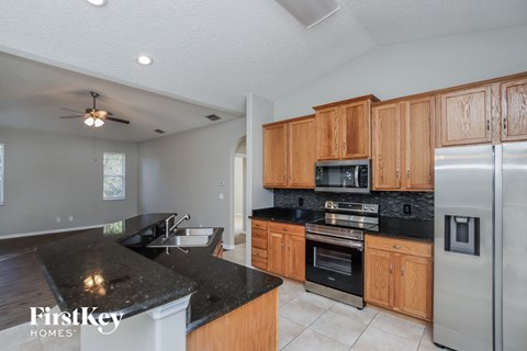 A kitchen with wooden cabinets and a black countertop.