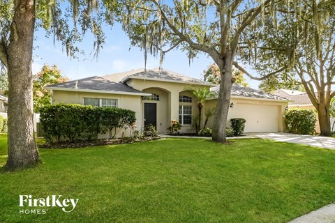 a home with a lawn and trees in front of it