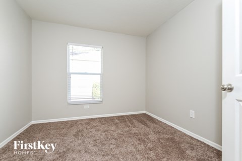a bedroom with a carpeted floor and a window