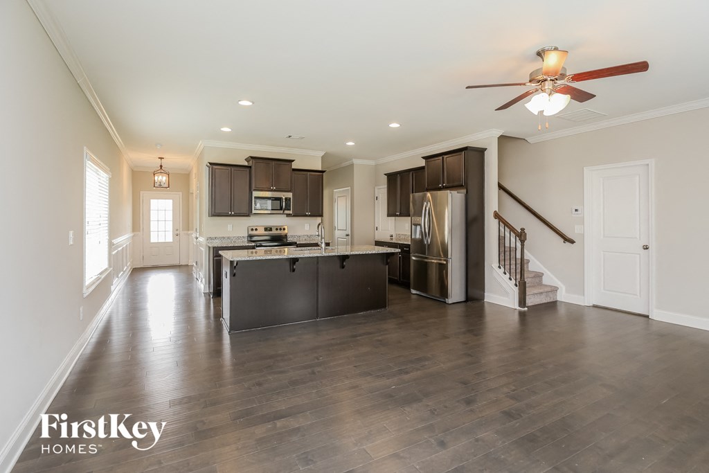 an open kitchen and living room with a ceiling fan