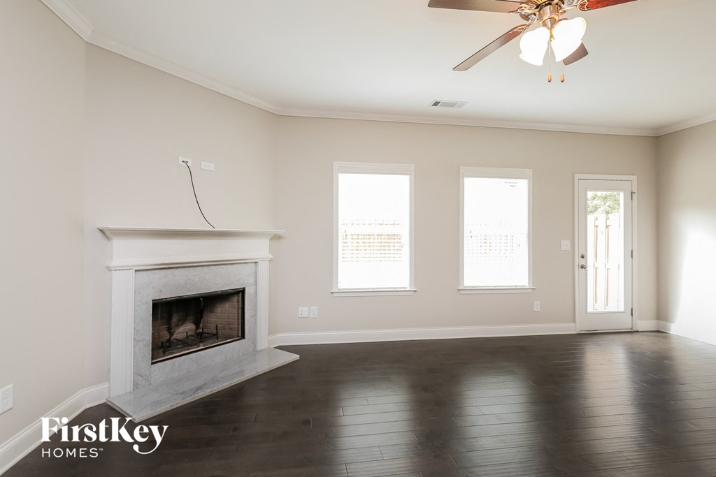 a living room with a fireplace and a ceiling fan