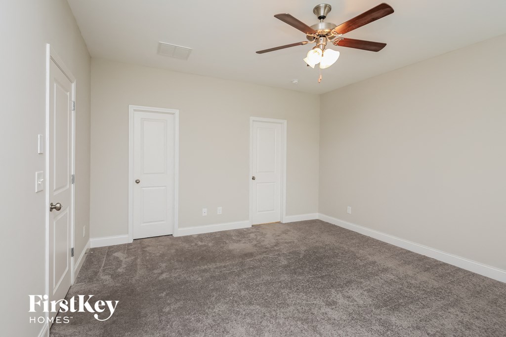 a bedroom with a carpeted floor and a ceiling fan