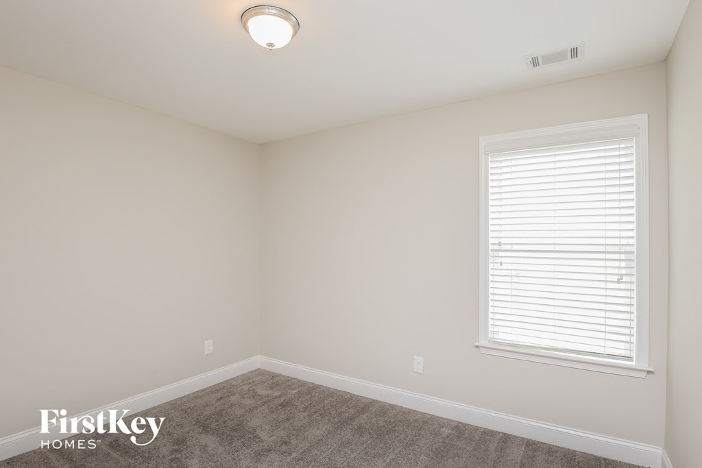 a bedroom with a carpeted floor and a window