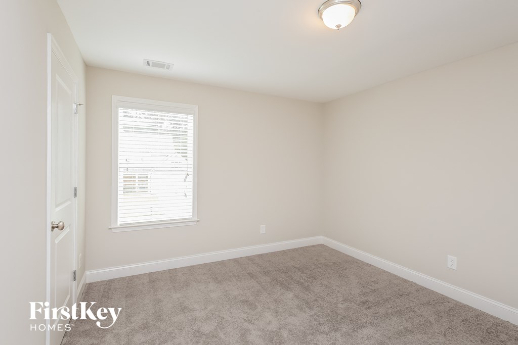 a bedroom with a carpeted floor and a window