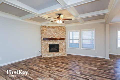 A room with a fireplace and wooden floors.