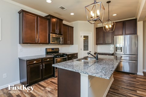 A kitchen with brown cabinets and a granite countertop.
