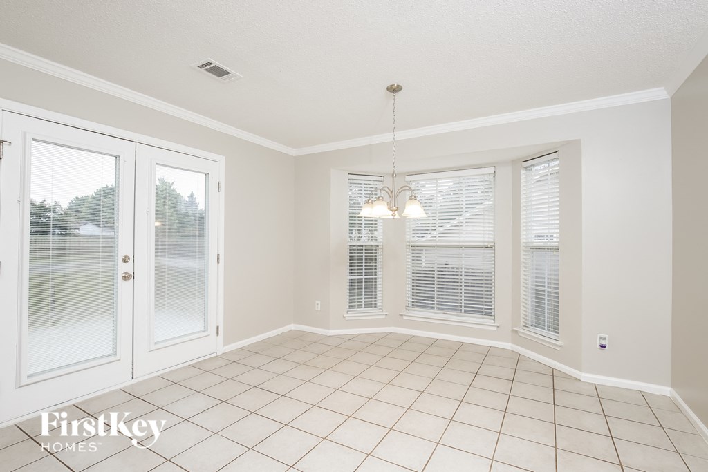 a dining room with windows and a door to a patio