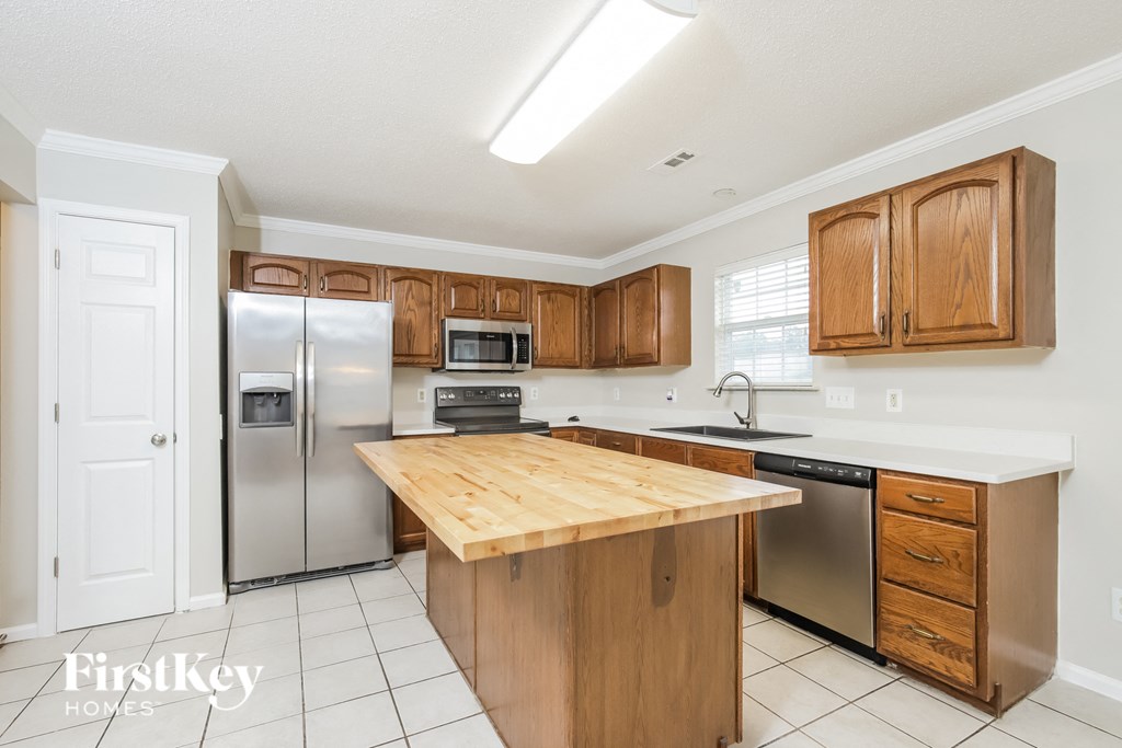 a kitchen with stainless steel appliances and a wooden counter top