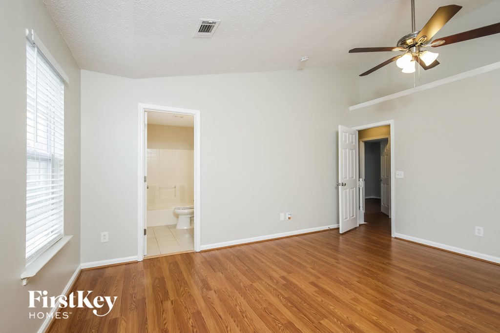 a living room with wood flooring and a ceiling fan