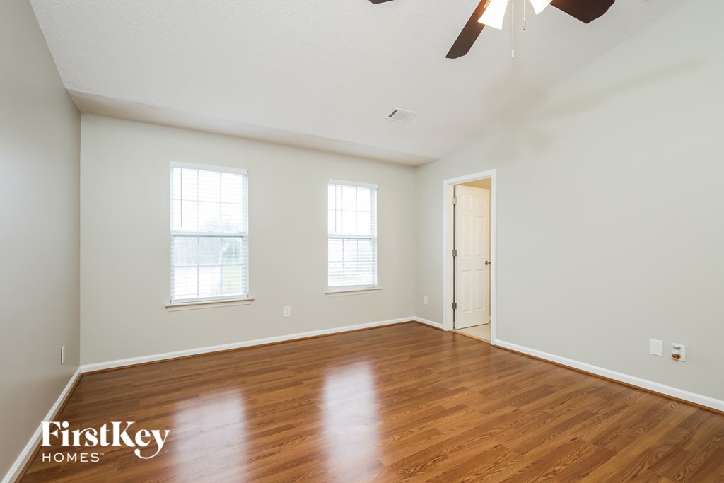 a living room with wood floors and white walls and a white door
