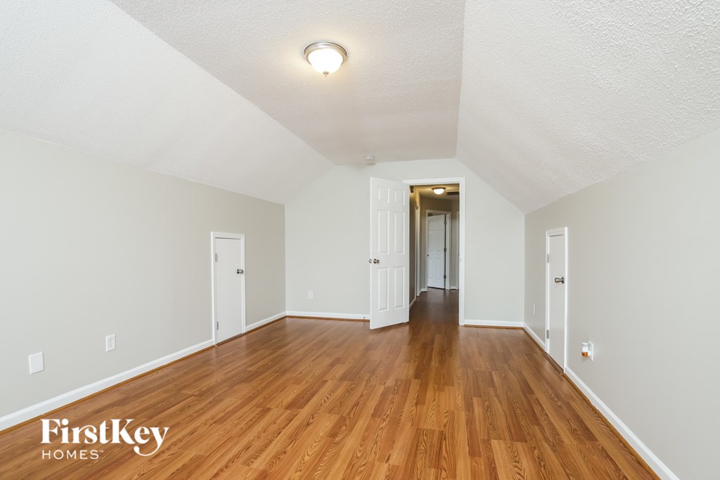 the living room and hallway of an empty house with wood flooring