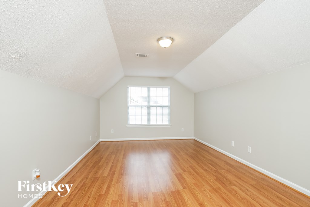 a spacious living room with hardwood floors and a window