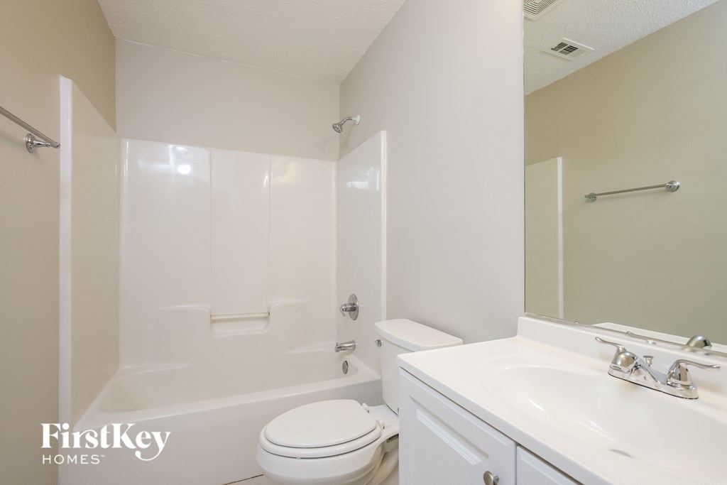 a white bathroom with a sink toilet and shower