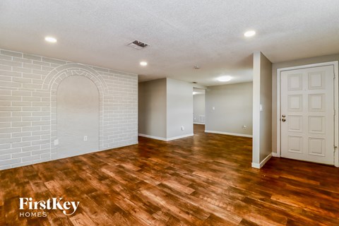 the living room and dining room with wood flooring and a white door