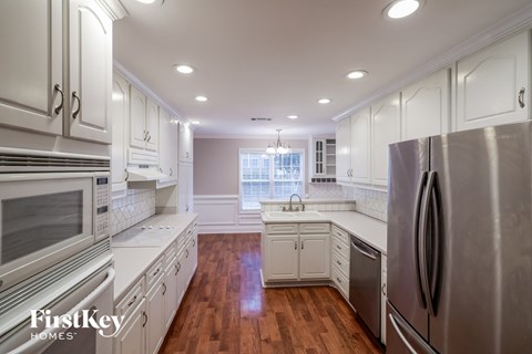 a renovated kitchen with white cabinets and stainless steel appliances