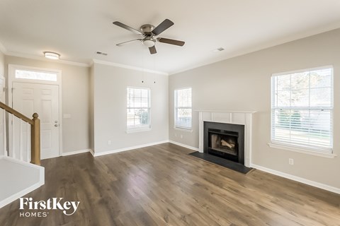 a living room with a fireplace and a ceiling fan