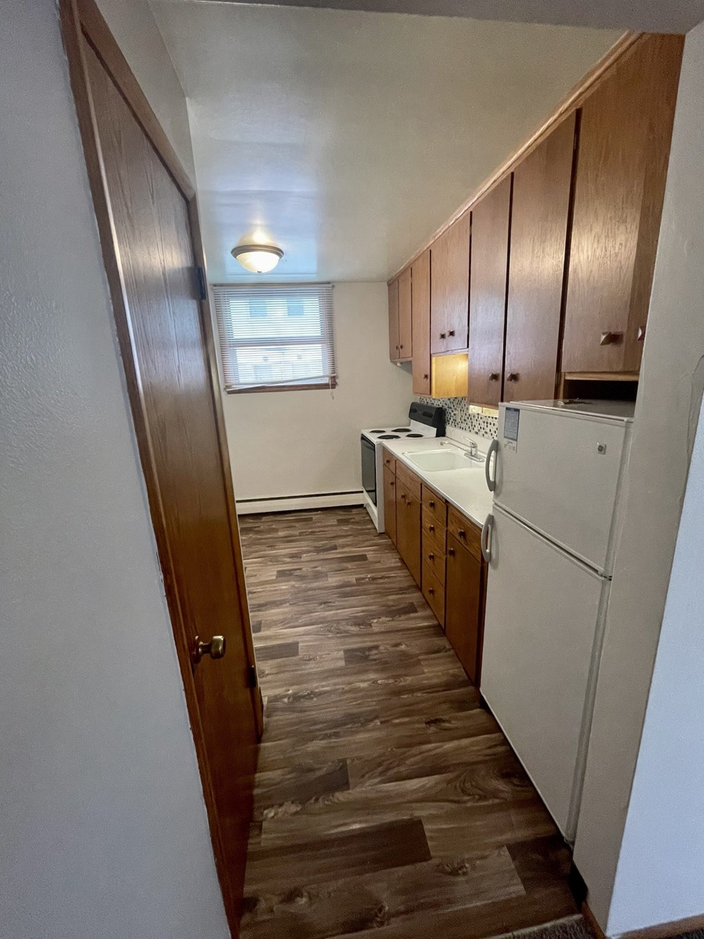 a small kitchen with a white refrigerator and a sink
