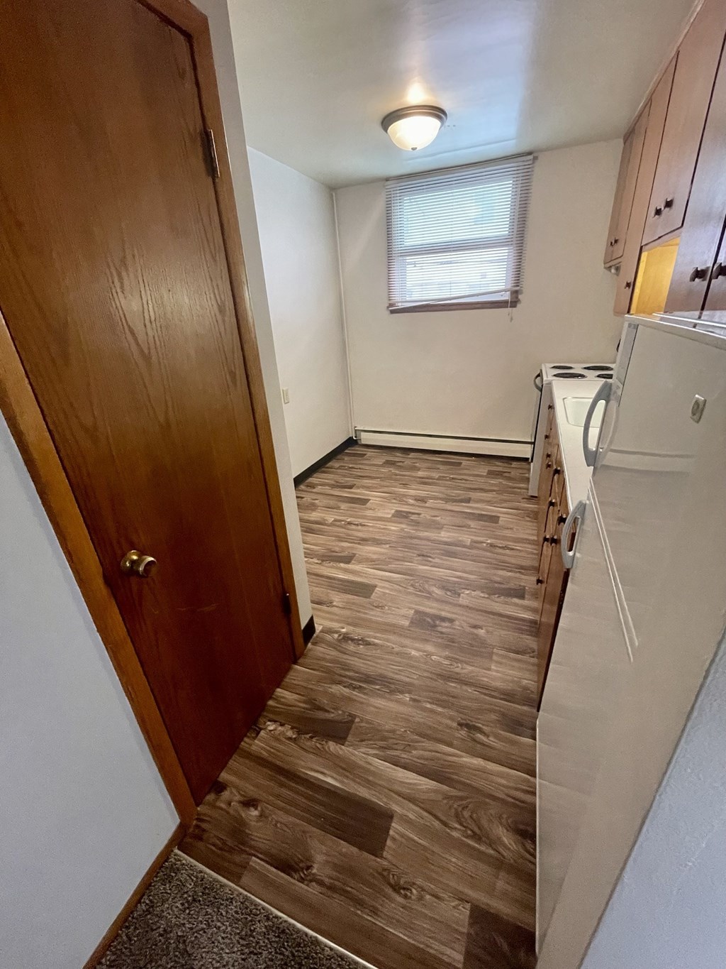 a small kitchen with a door to the laundry room