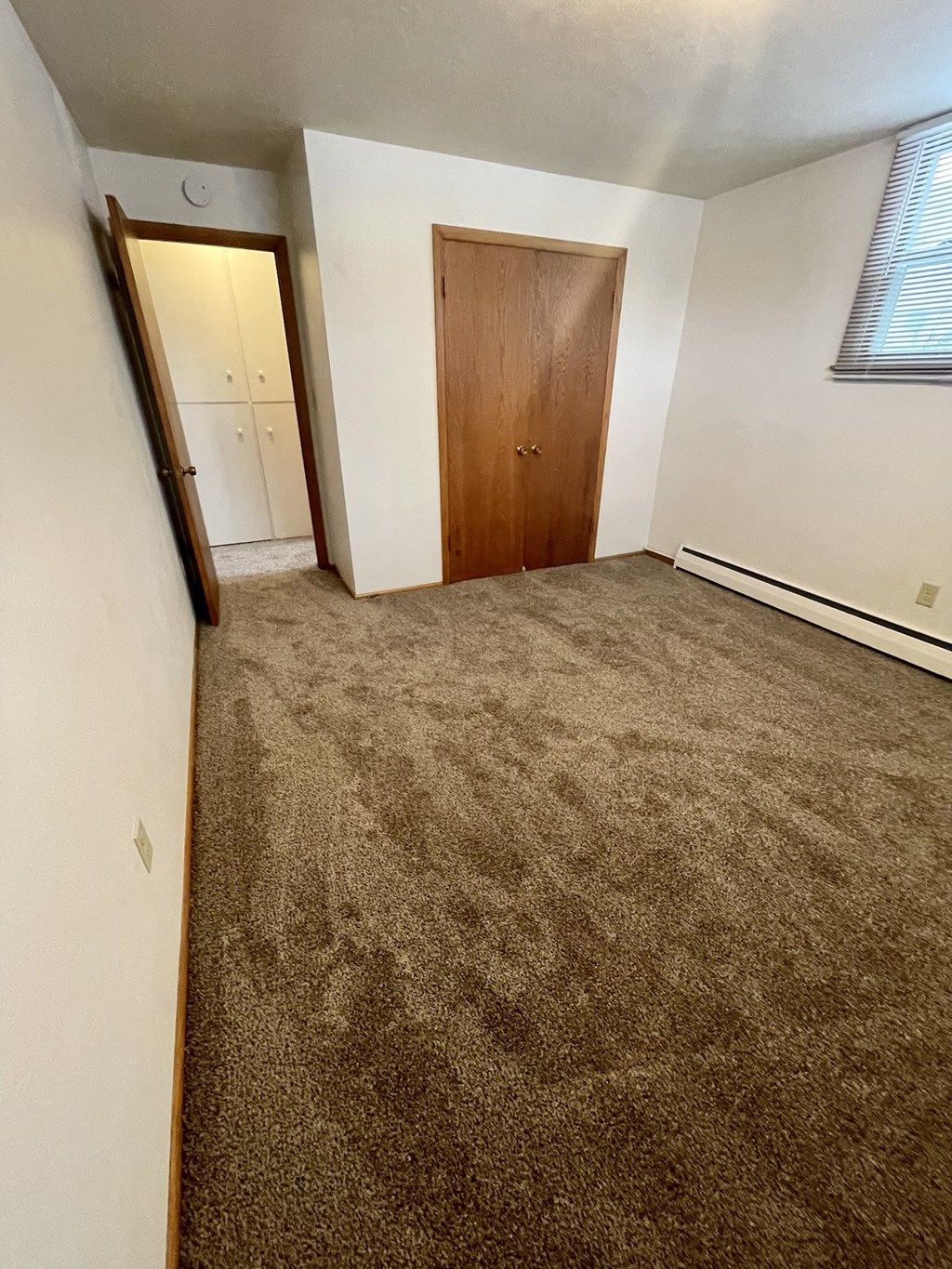an empty room with a carpeted floor and a door