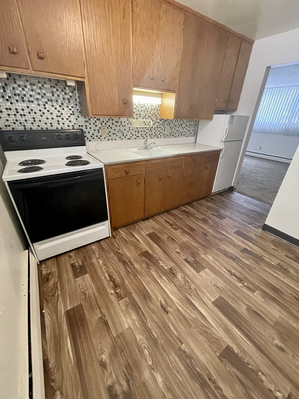 a kitchen with wooden floors and a stove and a sink