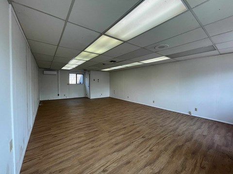 A room with wooden flooring and white walls.