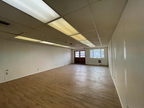 A large empty room with wooden floors and white walls.