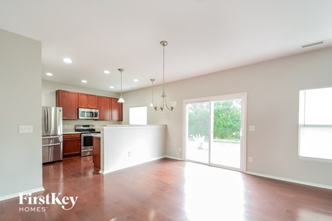 A spacious kitchen with wooden cabinets and a refrigerator.