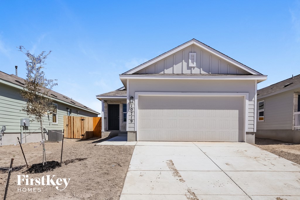 A house with a garage door is for sale by FirstKey Homes.