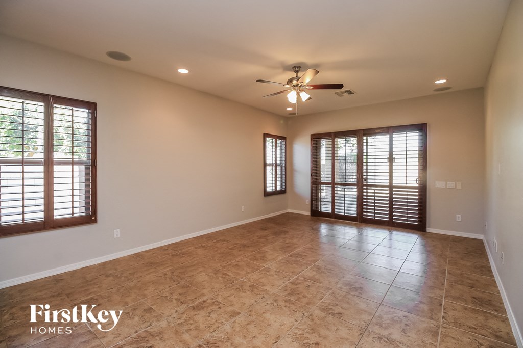 A spacious room with a ceiling fan and tiled floor.