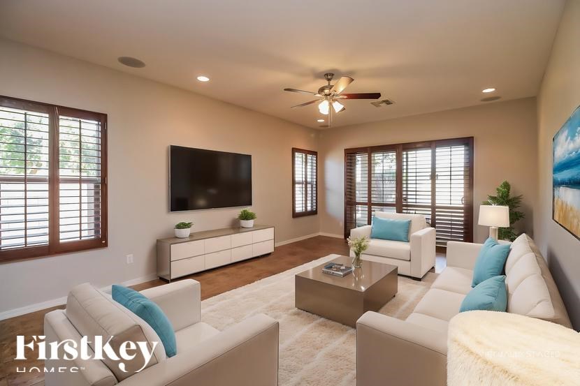A living room with a white couch, a coffee table, and a flat screen TV.
