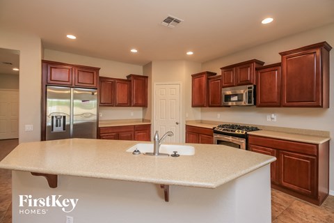 A kitchen with brown cabinets and a white island.