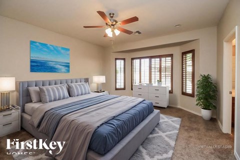 A bedroom with a large bed and a ceiling fan.