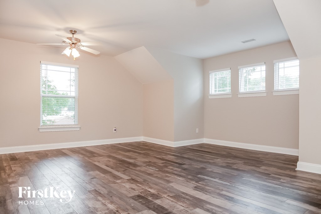 the living room with wood floors and a ceiling fan