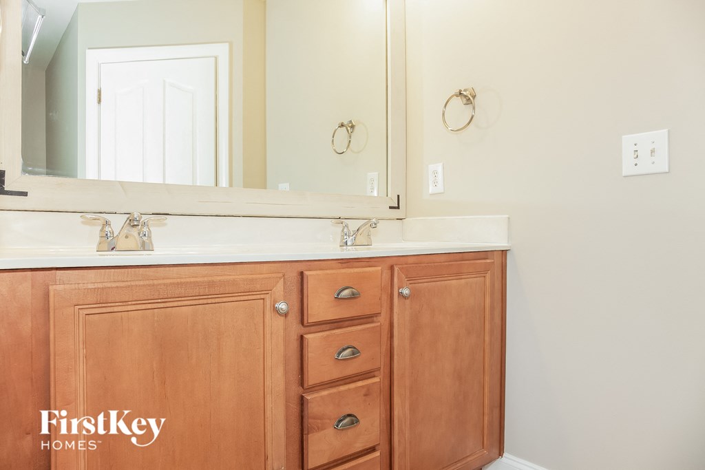 a bathroom with a sink and a mirror and a wooden vanity