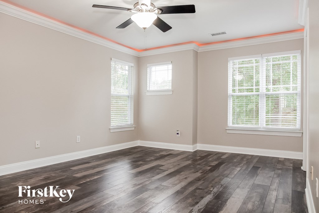 the living room with wood floors and a ceiling fan