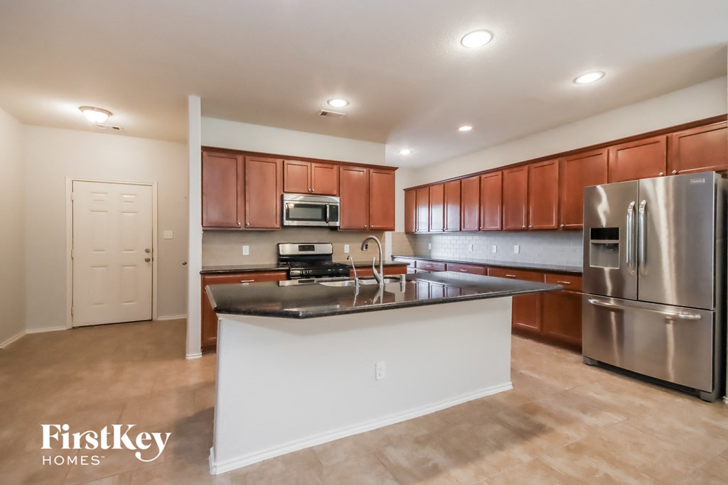 a kitchen with a large island and stainless steel appliances
