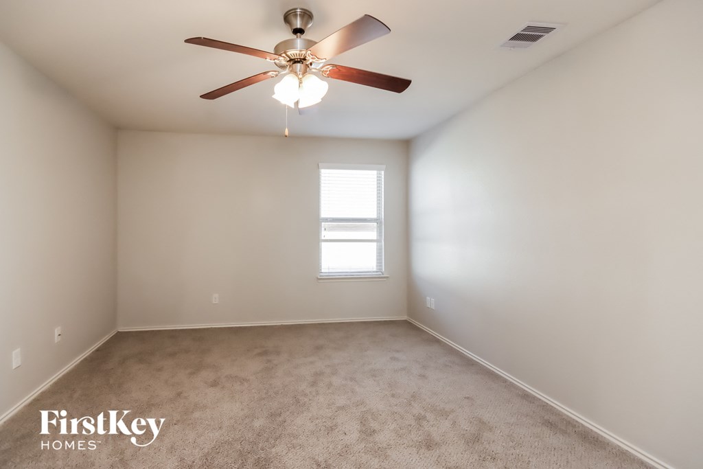 a empty room with a ceiling fan and a window