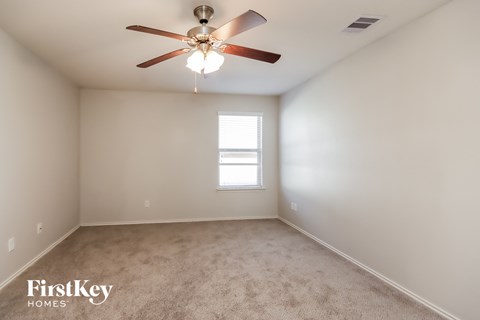 a empty room with a ceiling fan and a window
