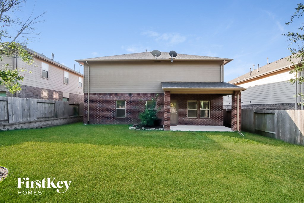 a backyard with a brick house and a lawn