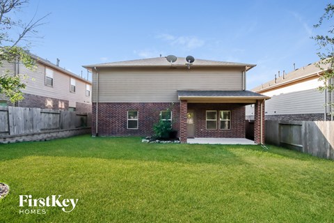 a backyard with a brick house and a lawn