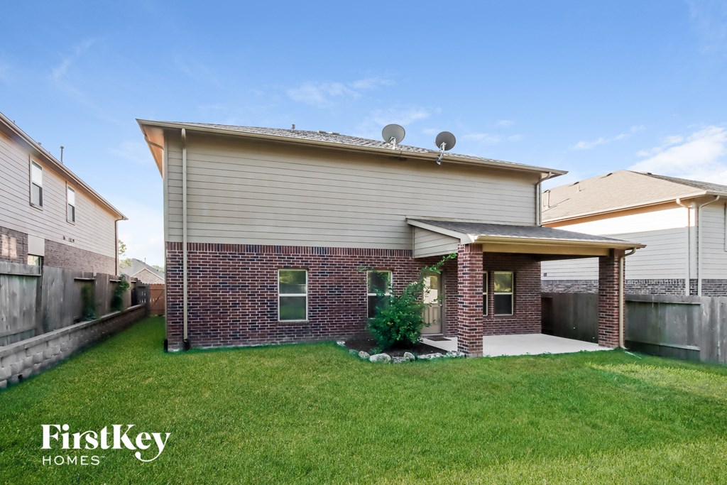 a small brick house with a lawn and a porch