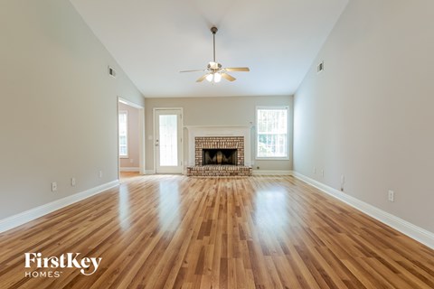 an empty living room with wood floors and a fireplace
